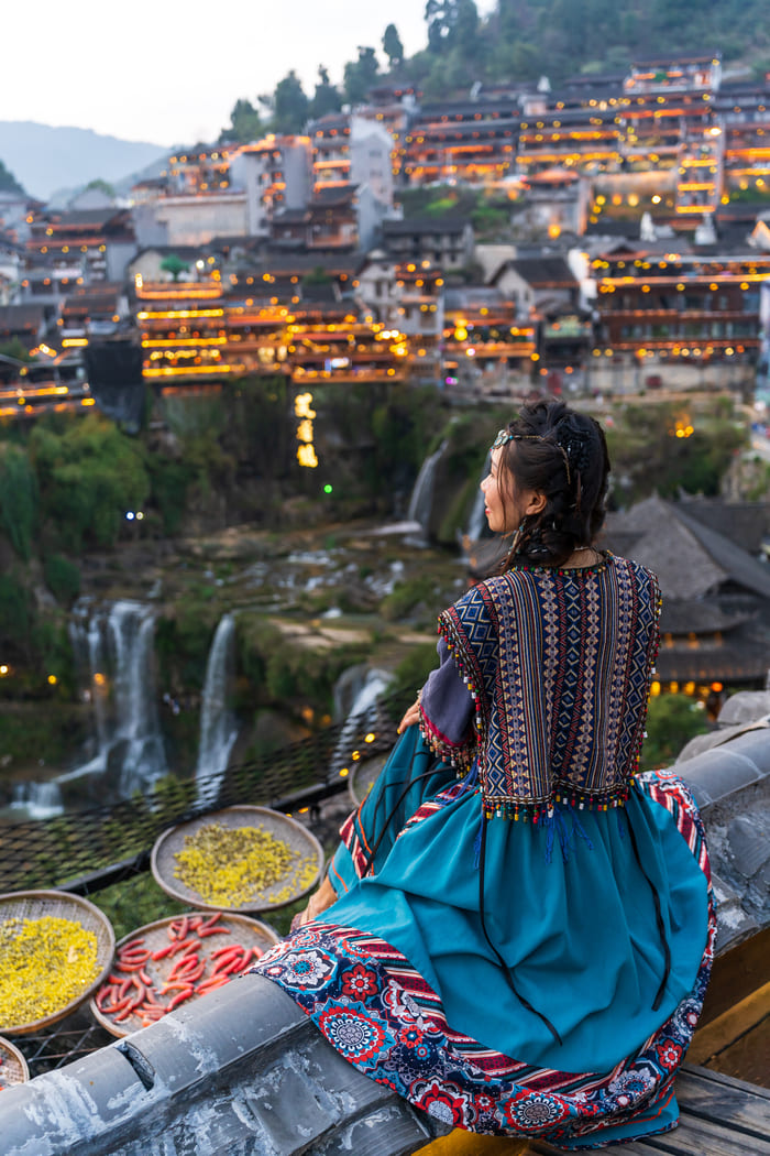 mujer de la region de lijiang observando un atardecer